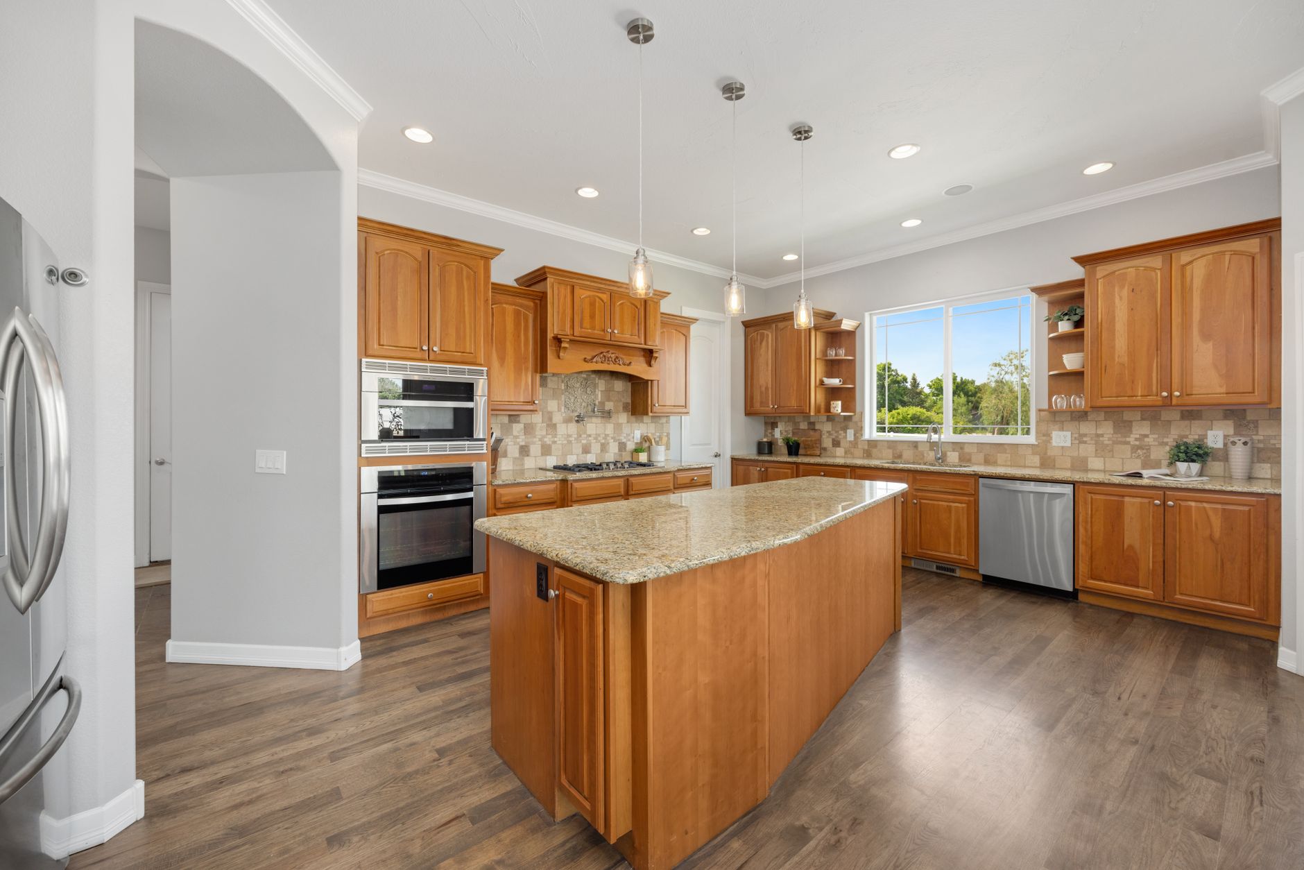 A bright and spacious kitchen featuring wood cabinets, an island, and modern appliances for a warm and in Yakima, WA